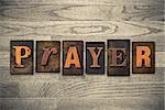 The word "PRAYER" written in wooden letterpress type.