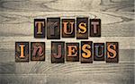 The words TRUST IN JESUS written in vintage wooden letterpress type.