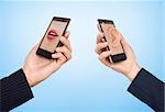 Phone cell concept. Man's hand holding phone with speaking woman's mouth in display and woman hand holding phone with ear in the screen.