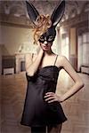 Charming, sexy Easter, black bunny in black,satin dress, red lips and wild, red hair.