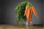 A bunch of fresh carrots in glass vase