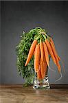 A bunch of fresh carrots in glass vase