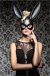 Sexy, dark, carnival, woman in black rabbit mask and black dress with nice hairstyle and dark make up.