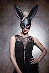 Sexy, pretty, elegant blonde woaman in carnival rabbit mask, balck dress and make up.