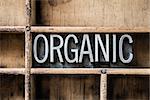 The word "ORGANIC" written in vintage metal letterpress type sitting in a wooden drawer.