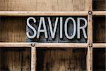 The word "SAVIOR" written in vintage metal letterpress type sitting in a wooden drawer.