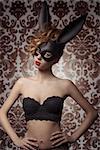 sexy woman with lace stylish lingerie posing with bizarre bunny mask in glamour portrait. Dark Easter