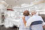 Senior Couple Looking Over Custom Kitchen Design Drawing and Photo Combination.