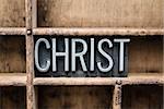 The word "CHRIST" written in vintage metal letterpress type in a wooden drawer with dividers.