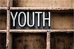 The word "YOUTH" written in vintage metal letterpress type in a wooden drawer with dividers.