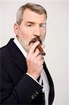 Mature businessman smoking a big cigar