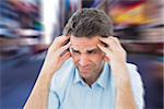 Man with headache against blurry new york street