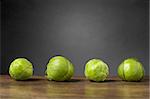 Four brussels sprouts on raw on wooden table