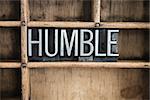 The word "HUMBLE" written in vintage metal letterpress type in a wooden drawer with dividers.