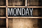 The word "MONDAY" written in vintage metal letterpress type in a wooden drawer with dividers.
