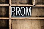 The word "PROM" written in vintage metal letterpress type in a wooden drawer with dividers.