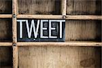 The word "TWEET" written in vintage metal letterpress type in a wooden drawer with dividers.