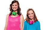 Teenagers posing with headphones around neck in front of camera