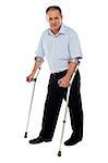 Old handicapped man with a walker  standing against white background