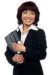Smiling female executive holding binder and looking at you