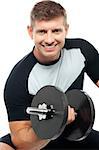 Closeup shot of masculine man doing biceps with dumbbell