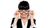 Cheerful woman taking off her spectacles. Studio white background shot