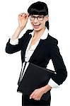 Professional woman in formal attire carrying files and adjusting her spectacles