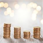 Coins stack in row on wooden background, financial concept. Focus on foreground with blur shinny background.