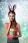 Pretty, easter girl with rabbit, fluffy ears and bucket of easter eggs. She wears to and jeans shorts. She has got nice make up.