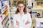 Portrait of a smiling pharmacist in lab coat looking at camera in the pharmacy
