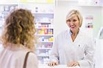 Pharmacist smiling at costumer at pharmacy