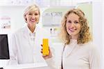 Smiling costumer with a medicine bottle at pharmacy