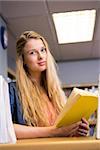 Pretty student studying in the library at the university