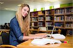 Student studying in the library with laptop at the university