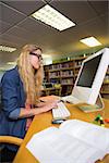 Student studying in the library with computer at the university