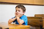 Focus pupil sitting at his desk at the elementary school