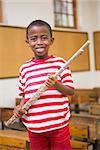 Happy pupil holding flute at elementary school