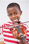 Happy pupil playing violin in classroom at the elementary school