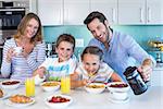 Happy family having breakfast together at home in the kitchen