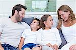 Happy family smiling at each other at home in bedroom