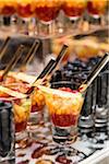 Close-up of Glasses of Fruit Cocktail and Shot Glasses of Blueberries on Dessert Table