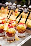 Close-up of Glasses of Fruit Cocktail and Chocolate Lollipops on Dessert Table