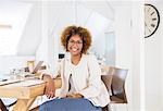 Portrait of woman sitting at desk in office and smiling