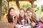 Three teenage girls having fun in tree house in summer