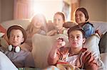 Group of teenagers watching tv on sofa together