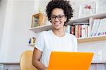 Young woman working with orange laptop in studio