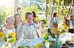 Young couple and bridesmaid during wedding reception in domestic garden