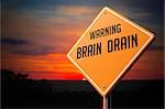 Brain Drain on Warning Road Sign on Sunset Sky Background.