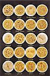 Large pasta dried food selection in round bowls over brown lokta paper background with titles.
