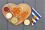 Onion ring snack food with dip selection and striped napkin.